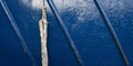 A up close photo of a rope and blue painted metal rough surface