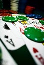 Up close photograph of playing cards and stacks of poker chips