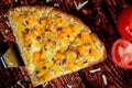 Up close and top view of special sweet pizza slice with mango and pineapple topped with a special hot sausage on wood table Royalty Free Stock Photo