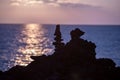 Up close view of silhouettes of tall lava rock formations against sunset over Pacific Ocean Royalty Free Stock Photo