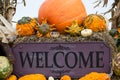 Up Close Welcome Sign Surrounded by Orange Pumpkins and Gourds and Corn