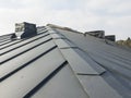 close up view of grey folding roof and chimney on waterproofing layer of house under construction Royalty Free Stock Photo