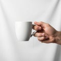 Up of a hand holding a plain white ceramic mug against a plain white Royalty Free Stock Photo