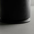 Up of a smooth black cylindrical object with a slightly wider base placed on Royalty Free Stock Photo