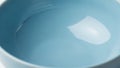 Up of a smooth round light blue ceramic bowl reflecting light on Royalty Free Stock Photo
