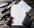 Up-to-date travel kit: medical mask, binoculars, flask, tactical knife on dark wooden background