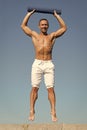 Up to healthy lifestyle. Man with yoga mat captured in mid air sky background. Sportsman with mat jump. Training outdoor