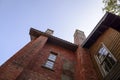 Old dark red brick building looking up to sky above blue Royalty Free Stock Photo