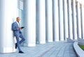 Upbeat businessman standing near column Royalty Free Stock Photo