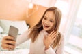 Upbeat girl taking selfie and waving at camera Royalty Free Stock Photo