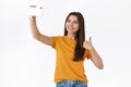 Upbeat, good-looking cheerful brunette woman in yellow t-shirt, record vlog or taking selfie near awesome place or shop