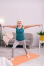 Upbeat senior woman doing morning calisthenics