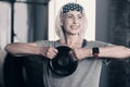 Upbeat senior woman holding a weight disc