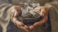 An upclose image of a practitioners hands holding a burning herb called moxa used in traditional Chinese medicine for