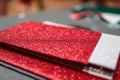 Upclose photo of a pile of colorful rectangular paper tiles covered with sparkling glitter