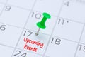 Upcoming Events written on a calendar with a green push pin to r