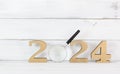 Upcoming 2024 New Year with Magnifying glass over white wood background, Search Goals Conccept Royalty Free Stock Photo