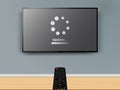 Update progress on LCD TV screen. Remote control is pointed at the TV on the wall Royalty Free Stock Photo