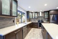 Updated contemporary kitchen room interior in white and dark tones.