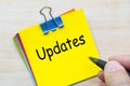 Updates text on yellow sticking notes. Business update concept Royalty Free Stock Photo