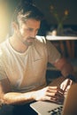 Updating the content on his website. a young man working on his laptop in a coffee shop. Royalty Free Stock Photo