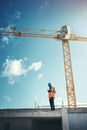 Updating project plans on the go. Shot of a young man using a smartphone while working at a construction site.