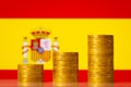 Upgoing graph made of coins stacked in front of Spain flag Royalty Free Stock Photo