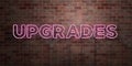 UPGRADES - fluorescent Neon tube Sign on brickwork - Front view - 3D rendered royalty free stock picture