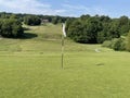 Uphill golf hole shot from behind with a green, and trees Royalty Free Stock Photo