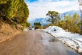 Uphill road in winter at banikhet dalhousie himachal pradesh india with sideways full of snow. Scenic winter view from the asphalt Royalty Free Stock Photo
