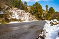 Uphill road in winter at banikhet dalhousie himachal pradesh india with sideways full of snow. Scenic winter view from the asphalt Royalty Free Stock Photo