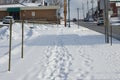 Uphill Snow-covered Sidewalk With Footprints Royalty Free Stock Photo