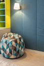 Upholstered bean bag or pear-shaped chair with filling, with geometric patterns, triangles, in children`s room. Neutral tones.