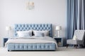 Upholstered bed in a luxurious bedroom in soft blue and gray tones