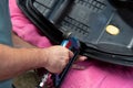 Upholsterer& x27;s hands stitching leather parts to repair a seat.