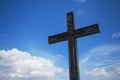 Uplifted christian cross on a blue cloudy sky