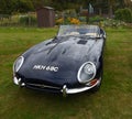 Classic Dark Blue 1965 Jaguar E Type Convertible isolated parked on grass.