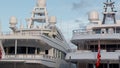 The upper decks of two white megayachts are moored in the port Hercules in Monaco at sunset, blue sky on background, no