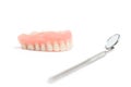 Upper dentures and dental mirror on white background Royalty Free Stock Photo