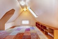 Upper empty room with vaulted ceiling and colourful carpet