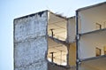 Upper floor of a derelict apartment building in the process of being demolished with large holes in the walls