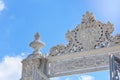 Upper fragment of the white carved marble gate of the Dolmabahche Palace against a blue sky