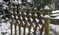 Upper half of an iron gate partially covered with snow