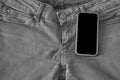 The upper part of old worn black jeans and a smartphone with a black screen Royalty Free Stock Photo