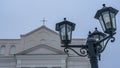 The upper part of the street lights in the old style on the background of the dome of the Catholic church.