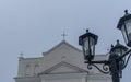 The upper part of the street lights in the old style on the background of the dome of the Catholic church