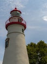 Upper section of the Marblehead Lighthouse with cloudy blue sky in background