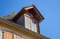 Upper storey with dove and nest outside. Facade of old wooden building. Birds and exterior of old house. Attic window with pigeon. Royalty Free Stock Photo