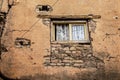 Upper story window with pretty lace curtains and one page open in very grungy and crumbling wall with utility line diagonal - wall