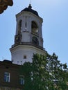 The upper tier of the Clock Tower, a former bell tower with a dome, clock and weather vane against the blue sky